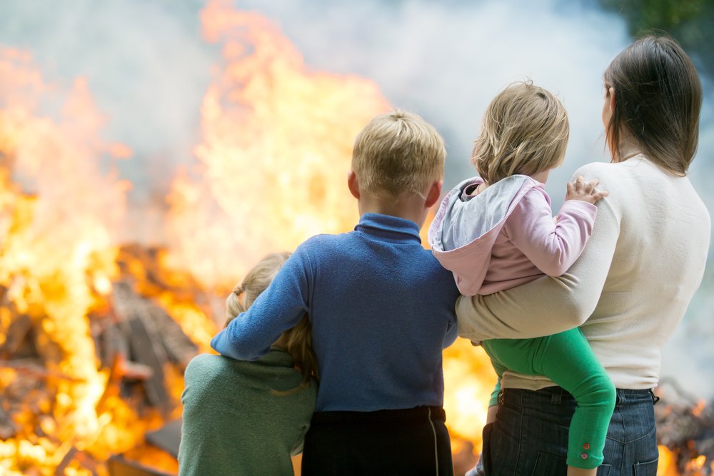Family,Mother,With,Children,At,Burning,House,Fire,Accident,Background